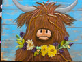 highland cow with flower lei